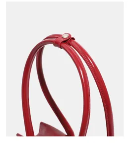 Red glossy leather handbag handle detail, stylish belt design, premium shoulder bag close-up