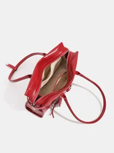 Women red patent leather shoulder bag stylish commuter handbag with top handles and zipper.