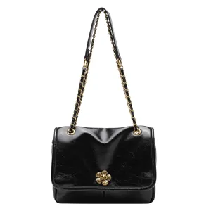 Black patent leather chain shoulder bag with stylish flower turn-lock and chic strap.