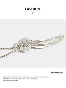 Exquisite rhinestone bucket bag detail with sparkling crystal ball and metal tassel chain.