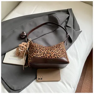 Leopard print underarm shoulder bag with cute plush dog charm, stylish PU leather trim design.