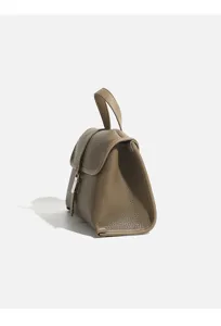 Detailed side view of women taupe leather top handle handbag with elegant metallic clasp.