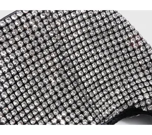 Close-up detail of luxury sparkling silver rhinestone women handbag surface texture.
