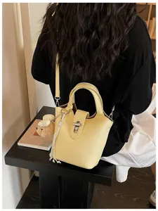 Yellow leather bucket bag detail, stylish women's crossbody shoulder bag with metal lock.