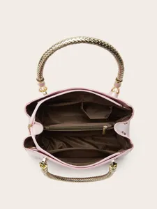 Pink patent leather handbag with braided gold handles, large capacity tote bag detail view.