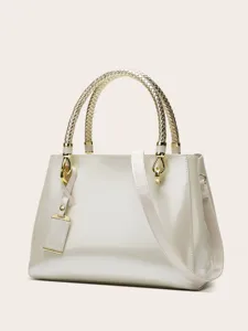 Patent leather handbag detail featuring braided gold handles and metallic hardware charms.