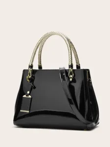Elegant black patent leather handbag detail featuring a stylish gold woven top handle and hardware.