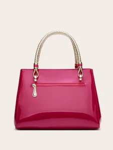 Close-up detail of glossy patent leather handbag with golden braided handle and metal hardware.