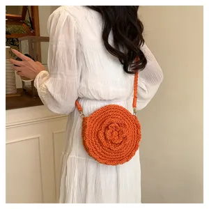 Detailed shot of a stylish orange crochet crossbody bag with a lovely floral motif design.