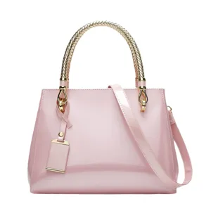 Fashion candy pink patent leather handbag with metallic braided handle and shoulder strap.