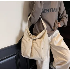 Casual canvas crossbody bag with multiple front pockets, minimalist style for daily use.