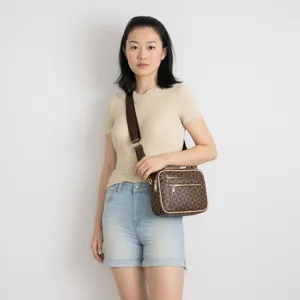 Detailed view of a fashionable brown geometric print crossbody bag with multiple zip pockets.