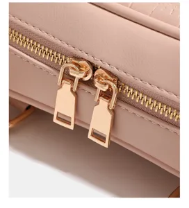 Primo piano dettaglio di borsa a spalla rosa cerniera lampo metallo oro e pelle fine.