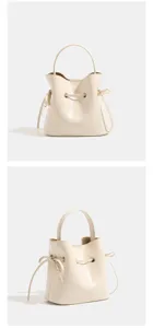 Elegant beige bucket bag with top handle and drawstring design, perfect for daily outfits.