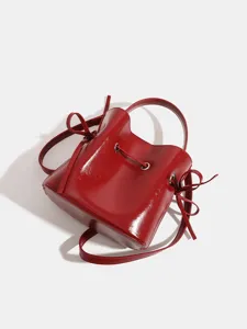 Red patent leather bucket bag for women, stylish crossbody and handheld handbag for summer 2025.