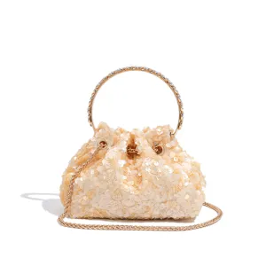 Close-up view of the sparkling sequin handbag featuring a chic metal round handle and chain strap.