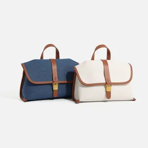 Chic contrast color denim canvas messenger bag with leather trim and metal lock closure for women.