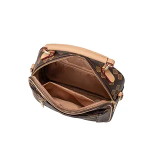 Detailed view of the brown checkerboard handbag showing open interior compartments and smooth zippers.