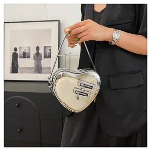 Détail sac bandoulière cœur argenté, sac à main métallique élégant, accessoire chic.