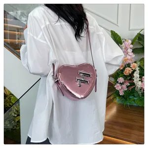 Sac bandoulière cœur brillant rose détail montrant le design élégant avec fermetures éclair.