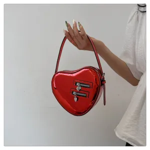 Sac à main en forme de cœur en cuir vernis rouge avec doubles poches zippées et poignée chic.