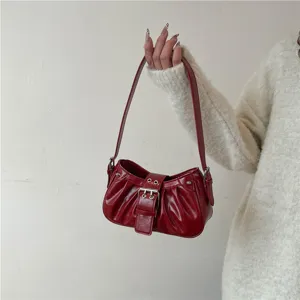 Red glossy ruched shoulder bag for women, vintage biker style baguette bag with metal buckle.