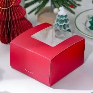 Red Christmas gift box with clear window, festive paper packaging for gifts and holiday treats.