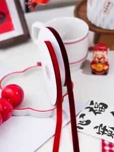 Red velvet ribbon spool for DIY gift packaging, Christmas and New Year decor crafts.