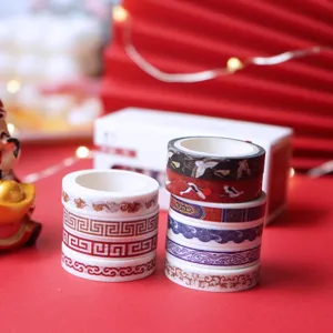 Close-up view of festive red washi tape rolls with traditional patterns for journals.