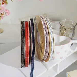 Nastro in tessuto decorativo con stampa di lettere per confezioni regalo e progetti fai-da-te.