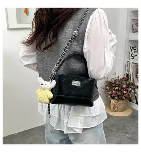 Detailed view of a fashionable black quilted leather shoulder bag featuring a chic metal chain.