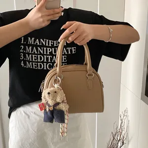 Korean style minimalist litchi grain handbag for women with cute teddy bear charm and handle.