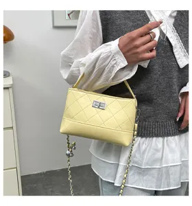 Detailed view of the yellow quilted shoulder bag featuring a chic chain strap and lock.