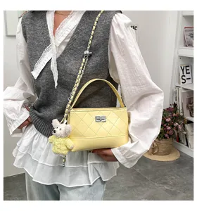 Yellow quilted shoulder bag with chain strap and cute bear pendant for women daily commuting.