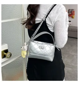 Silver quilted chain shoulder bag with top handle and cute bear pendant for women.