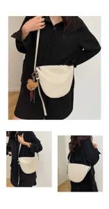 Detailed view of the elegant white underarm shoulder bag with cute bear pendant, chic design.
