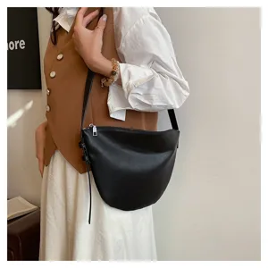 Detailed shot of a chic black crescent shoulder bag worn by a model, showcasing style.