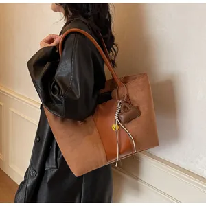 Dettaglio della borsa tote rétro bicolore che mostra la qualità di camoscio e pelle.