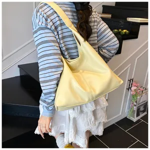 Yellow leather shoulder hobo bag detail shot showing texture and simple daily commuter style