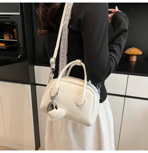 White bowling shoulder bag detail shot, vintage PU leather handbag with heart charm.