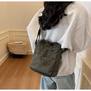 Sac bandoulière décontracté et léger avec cordon de serrage en vert foncé pour un usage quotidien.