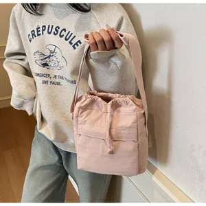 Vue détaillée du sac bandoulière tendance rose clair avec cordon, style décontracté et chic.