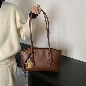 Chic brown leather shoulder bag for women, stylish underarm tote with elegant knot design.
