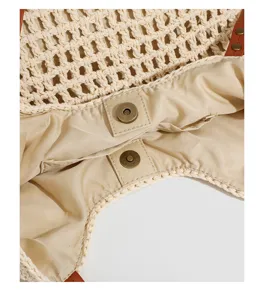 Beige crochet woven tote bag interior detail showing fabric lining and magnetic snap button.