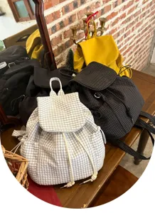 Casual plaid backpack detail showing drawstring flap, soft nylon fabric and daily commuting style.