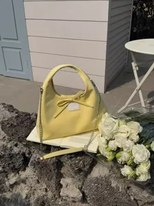 Yellow hobo shoulder bag with bowknot and metal chain strap for women casual daily use.