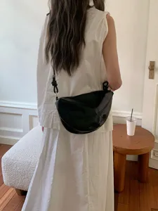 Black crescent shoulder bag scene display, versatile daily crossbody bag detail view.