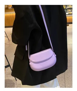 Light purple minimalist saddle crossbody bag, elegant shell design with slim shoulder strap.