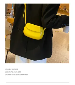 Detail view of the bright yellow saddle bag, showing its compact shape and sleek leather texture.