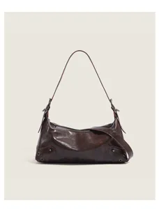 Detailed view of the dark brown leather shoulder bag with chic metal studs and grommet accents.